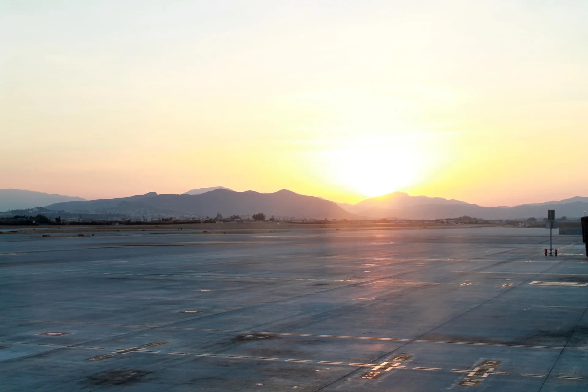 Runway at sunset with mountains beyond the airfield